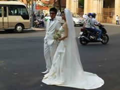大聖堂の前で記念撮影をする新婚カップル