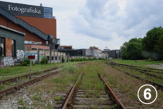テリスキヴィ・クリエイティブ・シティ（Telliskivi Loomelinnak） - 地区内の脇を走る鉄道線路と「Fotografiska Tallinn」の建物。テリスキヴィが鉄道関連の工業地区として発展した歴史を彷彿させる。